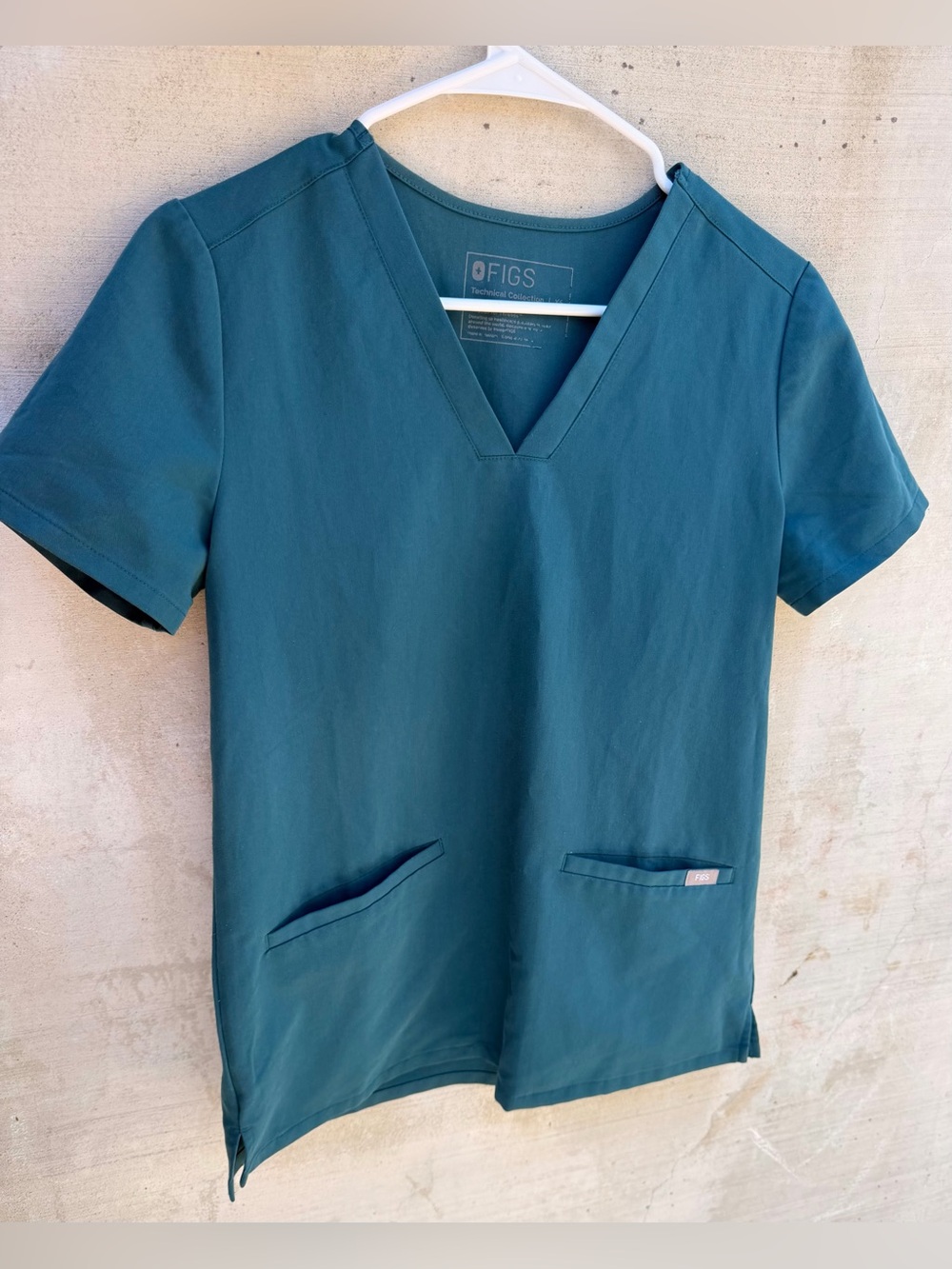FIGS women's V-neck scrub top featuring short sleeves and two lower front pocket